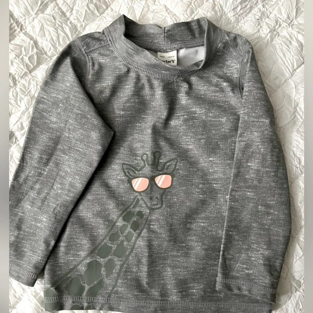 Swim shirt size 9m. Giraffe accent on the front. Like new Carter’s brand
